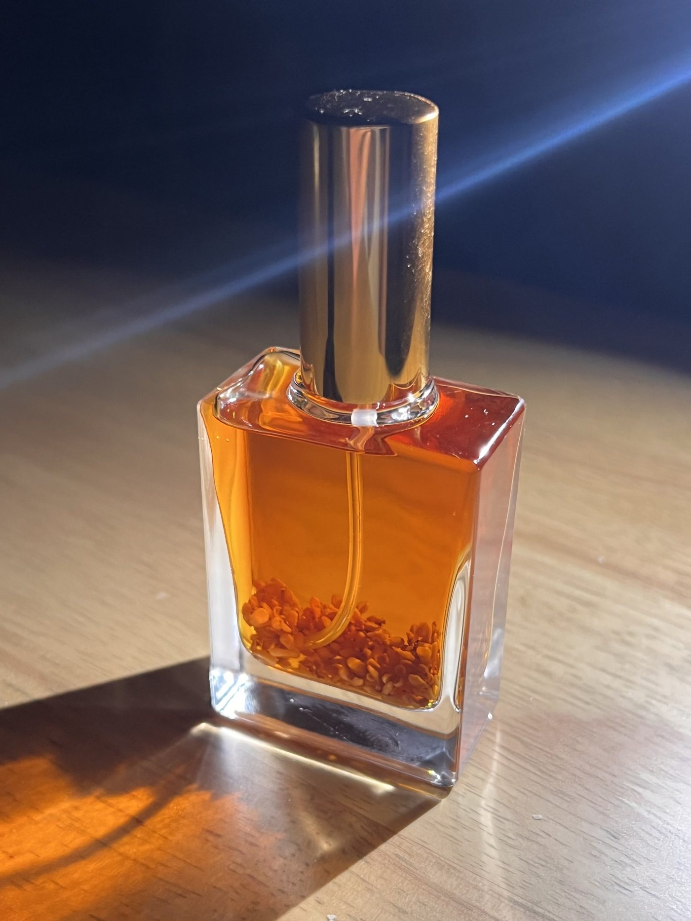 四角い瓶の底に金木犀の花が沈み、琥珀色の液体に光が差している