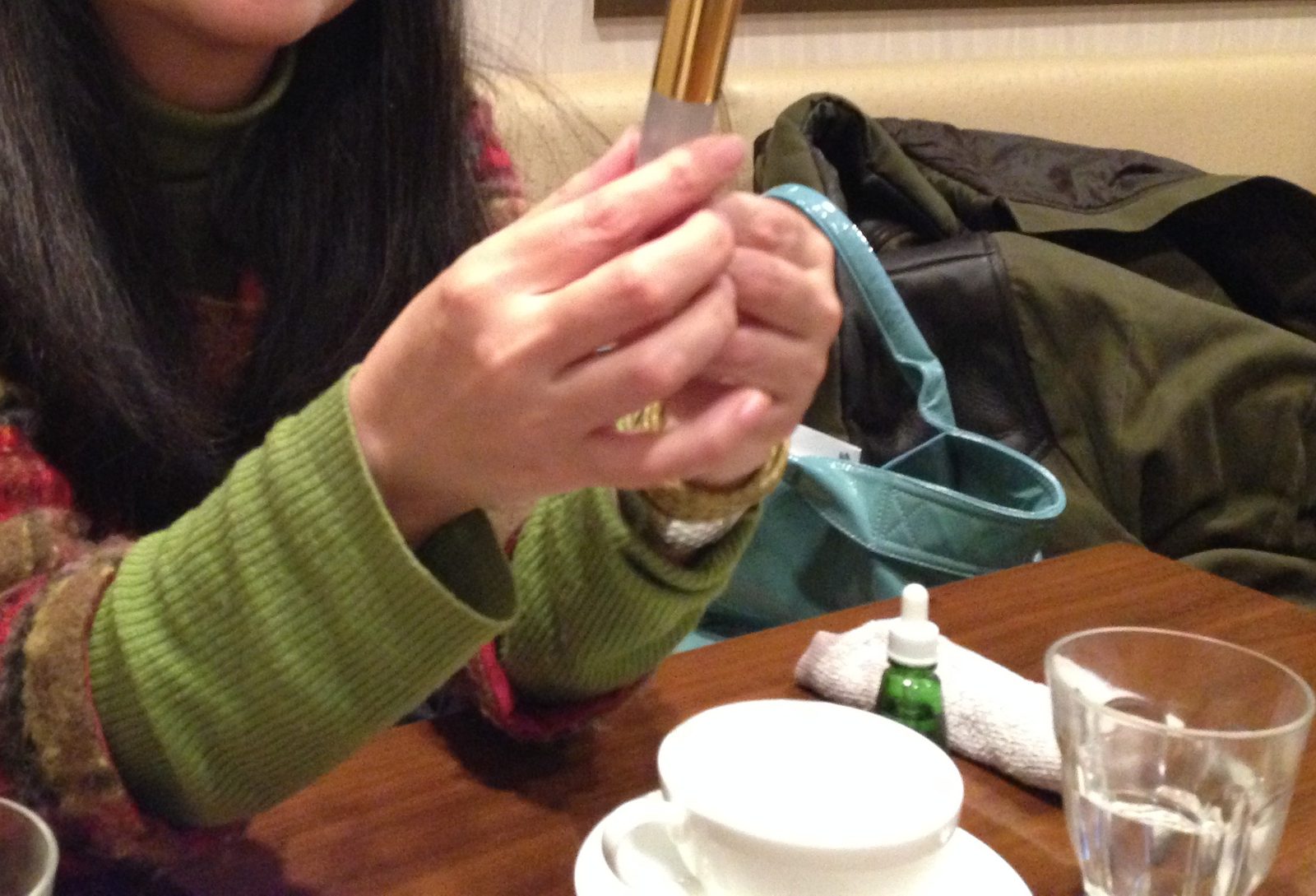 香りの瓶をやさしく両手で包み、見つめる手元